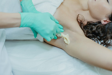 Sugaring. The girl beautician deals on sensitive areas of hands sugar wax.