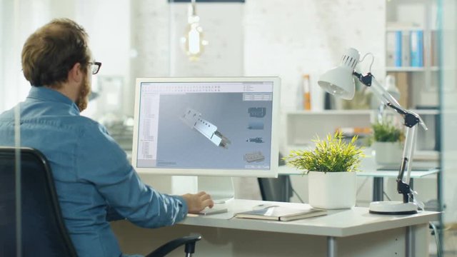 Industrial Design Engineer Works on a 3D Component in CAD Program on His Personal Computer. He Works in a Creative Modern Office.