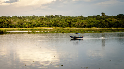 A small boat on the Nile river during sunset in Murchison Falls national park in Uganda.Too bad this place, lake Albert, is endangered by oil drilling companies