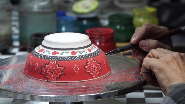 pottery art - artist woman draw on pottery porcelain