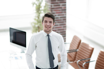 confident young businessman on background of office