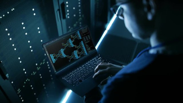 Data Center Engineer Holds Laptop and Works Controls System Stability.  