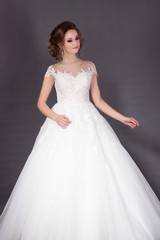 Fototapeta premium Beautiful bride in elegant white lace wedding dress
