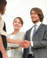 Businesspeople  shaking hands against room with large window loo