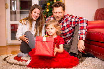 family, christmas, x-mas, winter, happiness and people concept - happy family opening gift box