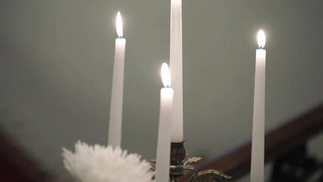 Four white candles fire indoors
