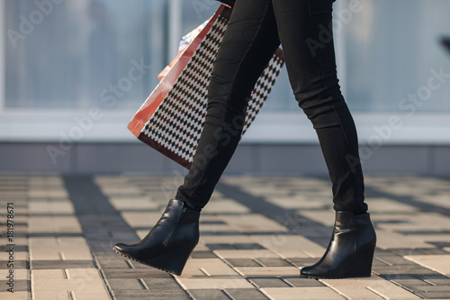 Sexy Woman Legs In Black Platform Shoes And Black Jeans With Shopping Bags Walking In The Sexy Woman Legs In Black Platform Shoes And Black Jeans With Shopping Bags Walking In The
