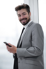 Stylish man in suit is reading information on phone