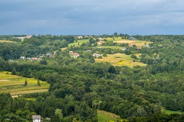 Summer rural landscape. Homes in the countryside among the green hills.