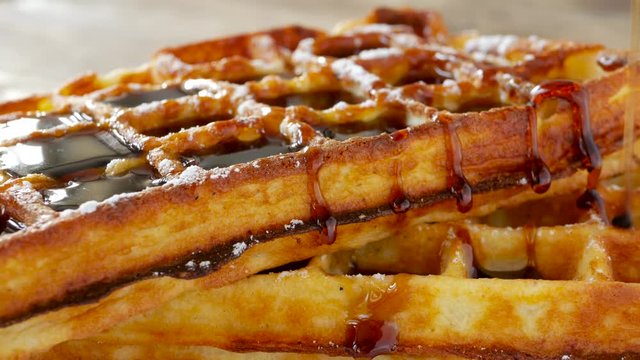 Homemade waffle with maple syrup topping and sugar powder, delicious sweet dessert.