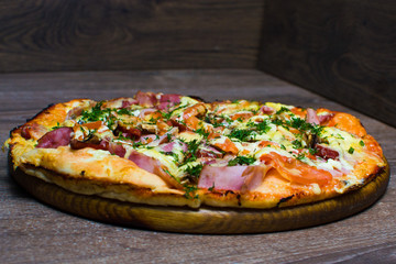 pizza with ham and cheese on a board