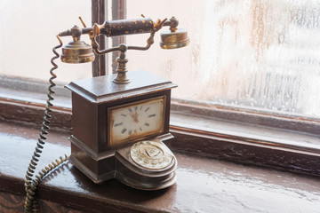 Vintage telephone with analog clock