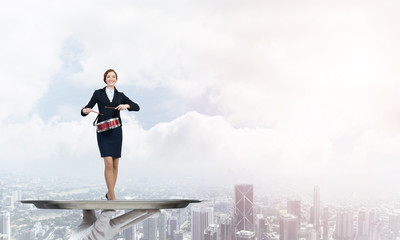 Attractive businesswoman on metal tray playing drums against cityscape background