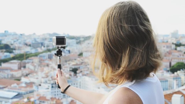 Woman traveller with camera shooting video.