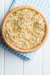 Dry rolled oatmeal in wooden bowl.