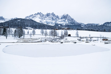 Wilder Kaiser mountainrange with snow with frozen lake, Going am Wilden Kaiser, Tyrol, Austria