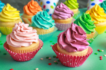 Tasty cupcakes on color background