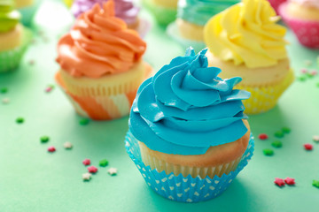 Tasty cupcakes on color background