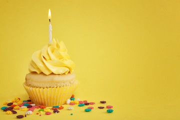 Tasty cupcake with candle on color background