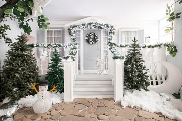 house entrance decorated for holidays. Christmas decoration. garland of fir tree branches and...