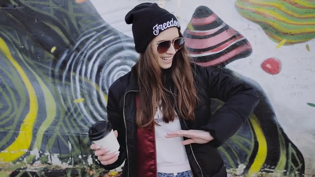 Happy young girl hipster having fun on city street slow motion