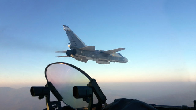 Military jet bomber Su-24 Fencer flying above the clouds.