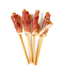 bread sticks with prosciutto isolated on white