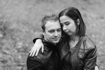 The guy with the girl walking in the Park , in a good mood. dressed in jackets, autumn time.