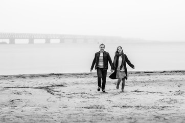 Fototapeta na wymiar the guy with the girl a walk along the coast . . deserted beach , dirty sand .