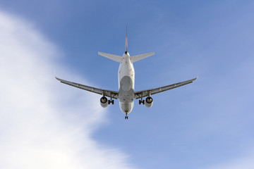 Fototapeta na wymiar Airplane flies against a background of white cloud