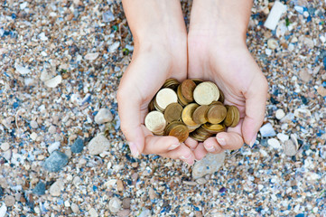 Handful of coins in palm female hands. Concept of saving and passive income