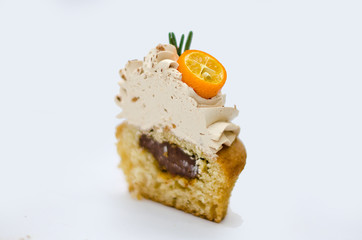 Cupcake with cumquat decoration cut in 2 pieces  isolated