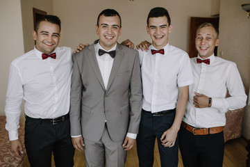 Handsome groom preparing for wedding ceremony in hotel room