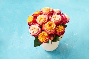 Bouquet of roses on blue background. Copy space, top view