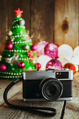 Vintage camera on Christmas background with decorations and Christmas tree