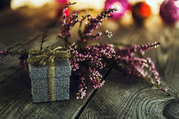 Christmas background with gift box and pink dried heather on wooden board
