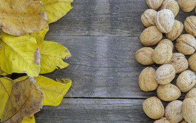 Walnuts and dry leaves on a wooden base