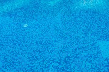 Blue abstract mosaic tiles at the bottom of the swimming pool, background.