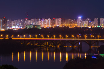 Fototapeta na wymiar Railway bridge over Dnipro and view of the residential area of Kiev