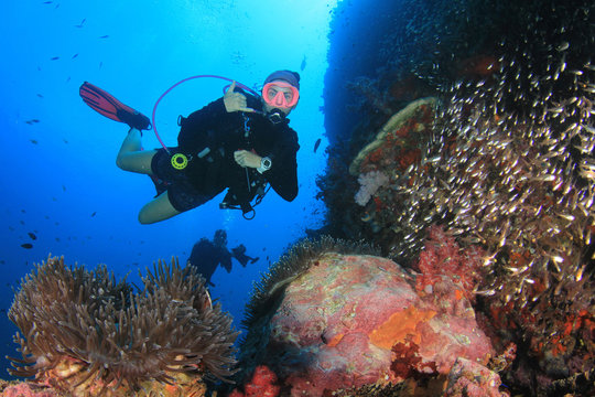 Scuba diver. Young woman scuba diving on coral reef
