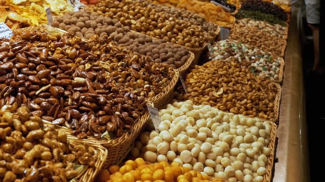 Large Counter of Dried Fruits, Nuts and Sweets at a Market in La Boqueria. Barcelona. Spain. Nuts, dry fruits on display at the market on the showcase. Stall with Various dried fruits at Mercat de