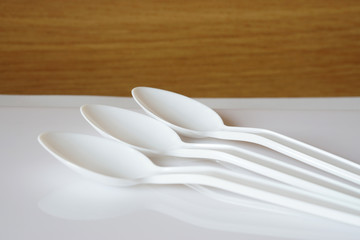 White three empty long plastic spoons  on the table