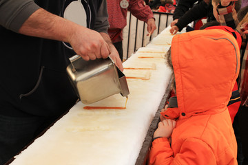 Making a maple syrup candy on the snow.  Maple syrup festival. 