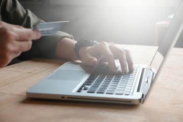 technology, shopping and banking concept - Close up of casual man holding credit card and using...