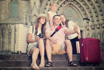 Fototapeta na wymiar family of tourists making selfie during travelling on European city