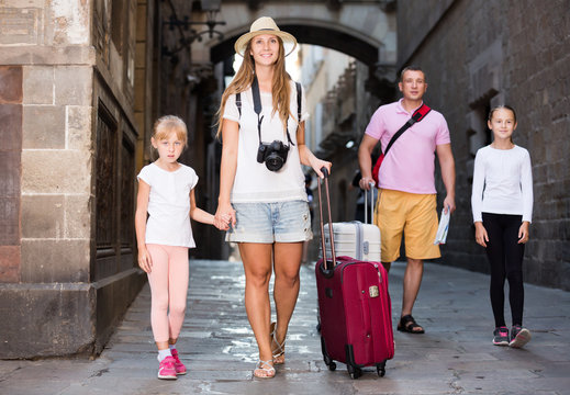 Adult family of tourists walking with suitcases