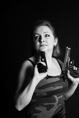 A middle aged, white, woman holds two semi automatic pistols against black