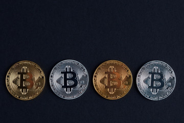 Four bitcoins on black background with copy space