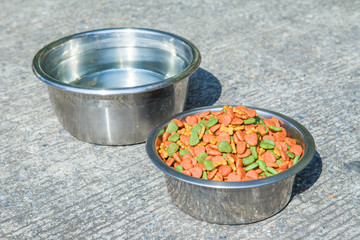 Dry dog food in in the stainless steel bowl and water
