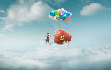 Happy sister enjoy with fantasy apple cycle ride  and floating in sky with bunch of colorful...